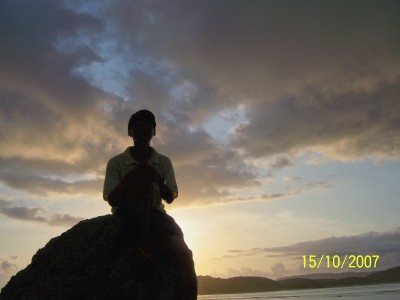 duduk di atas karang suatu sudut Pantai Kuta, Lombok
